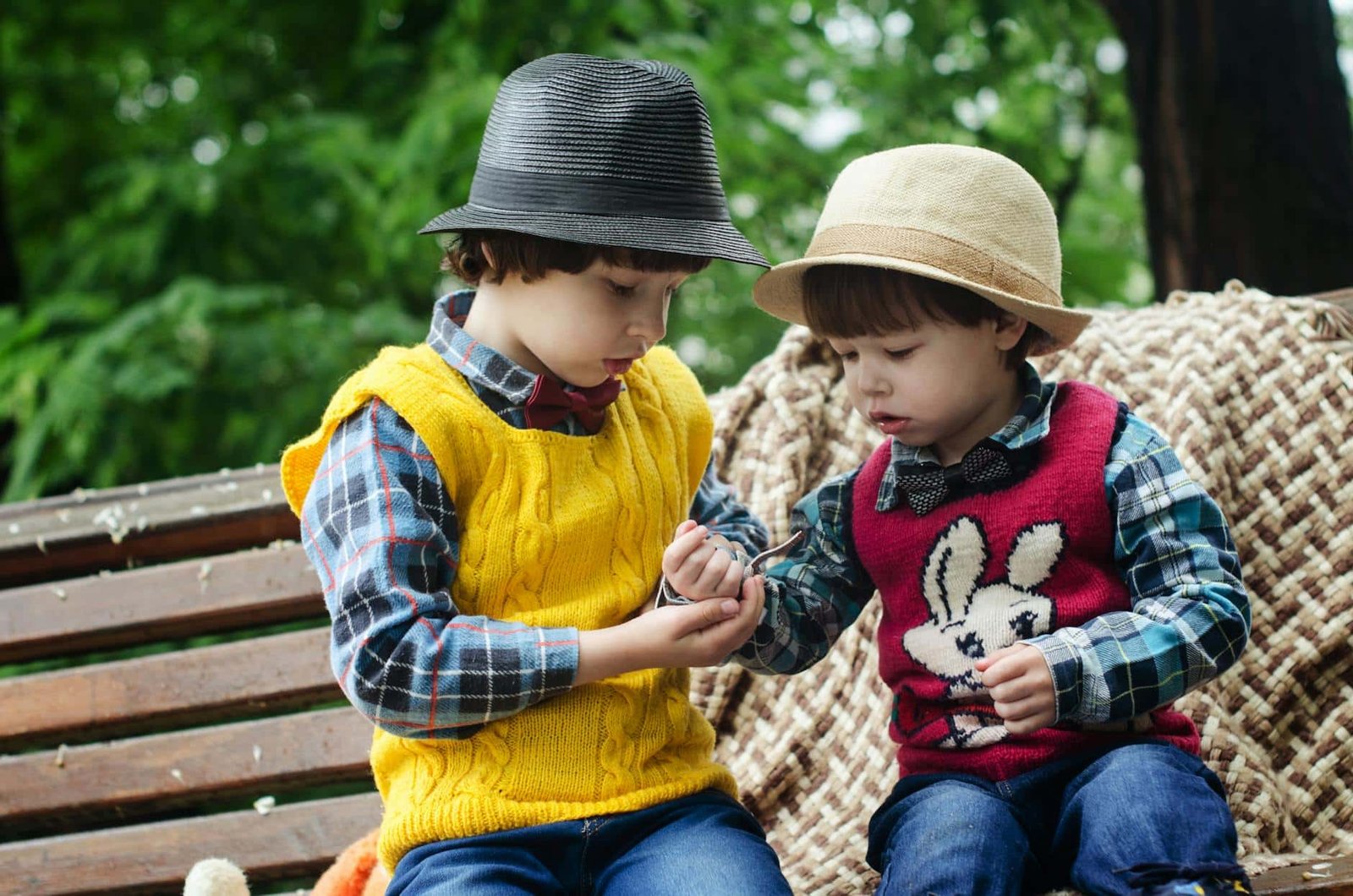 two-boys-sitting-on-bench-wearing-hats-and-long-sleeved-shirts-1619706/