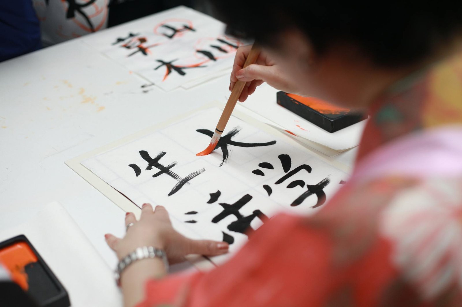 photo/person-holding-brush-drawing-kanji-script-1498273/